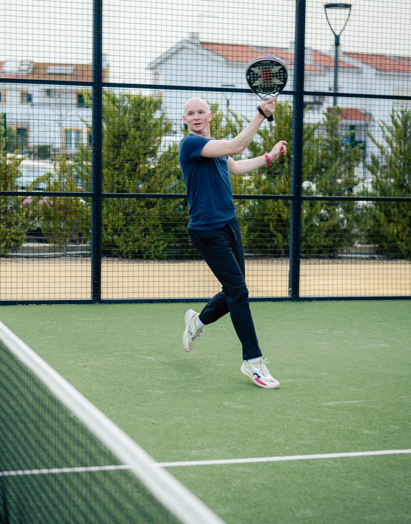 A padel rally in progress on an open-air court